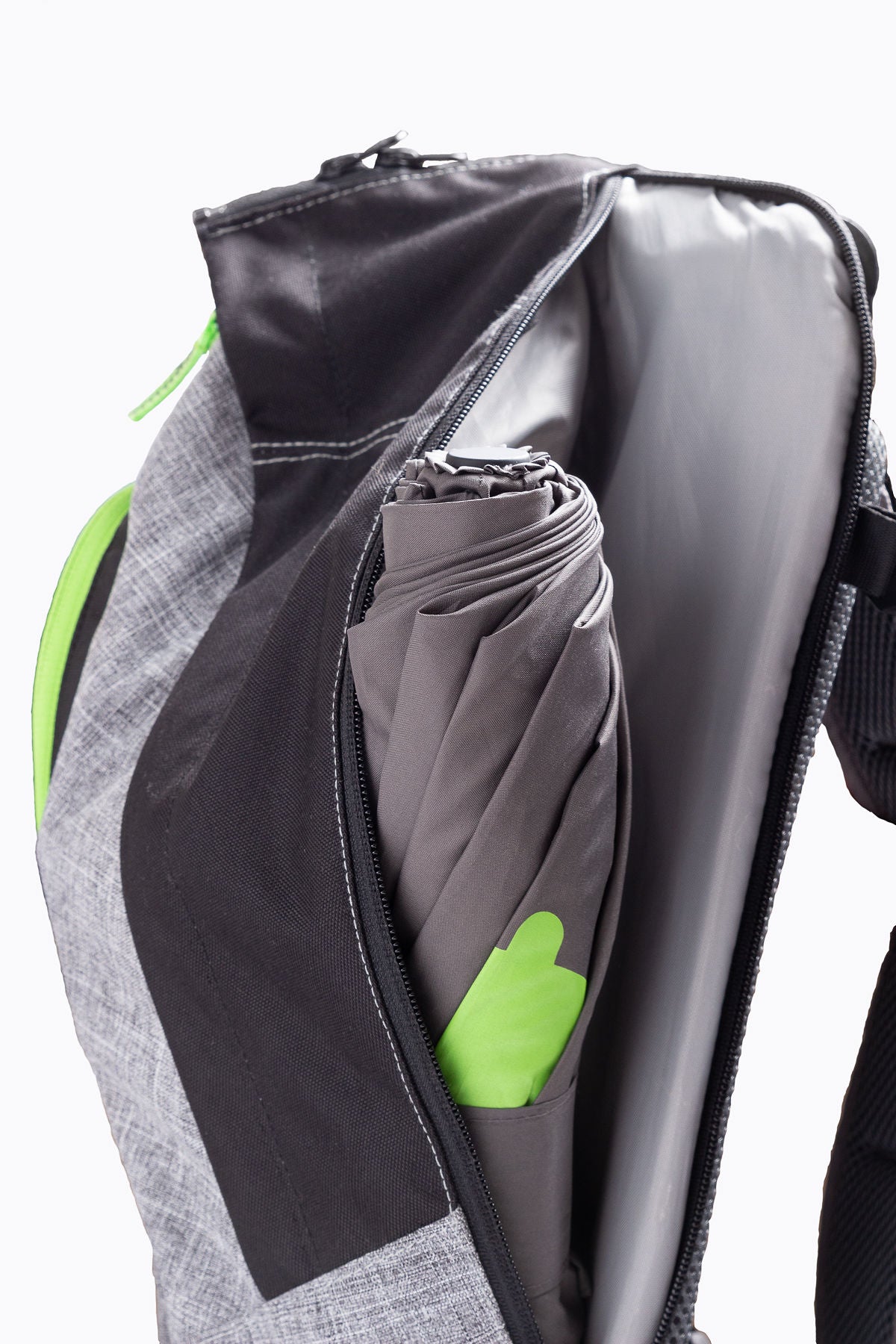 Umbre Excursion Backpack product image, grey with black and green highlights , showing waterproof pocket with included umbrella that is in storage.